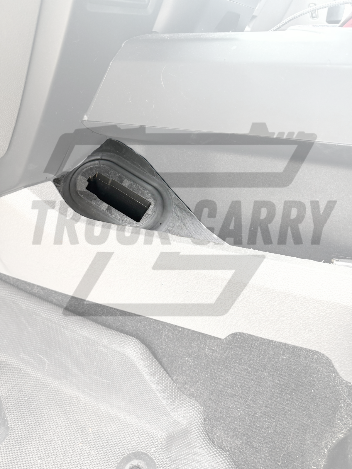 A close-up of a 'TRUCK CARRY holster installed into an f150 with a large semi-transparent 'TRUCK CARRY' watermark across the center.